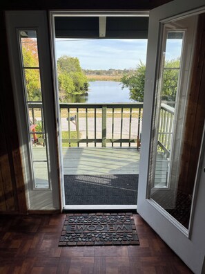 A wooden deck with a view of a lake and trees.