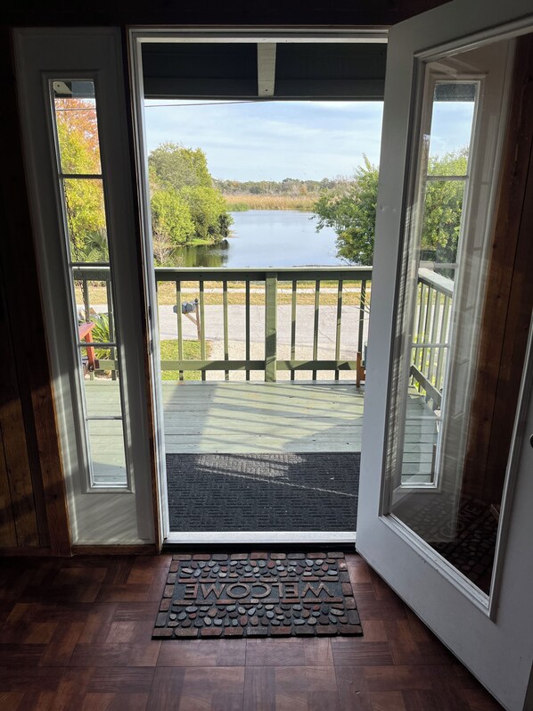 A wooden deck with a view of a lake and trees.
