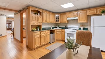 Una cucina con mobili in legno, un fornello e un frigorifero.