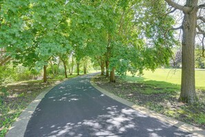 A paved pathway lined with trees in a park setting. - Creekside Grand Lodge (Barrington)