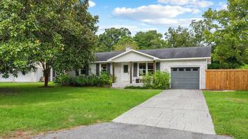 A single-story house with a front porch, a garage, and a well-maintained lawn.