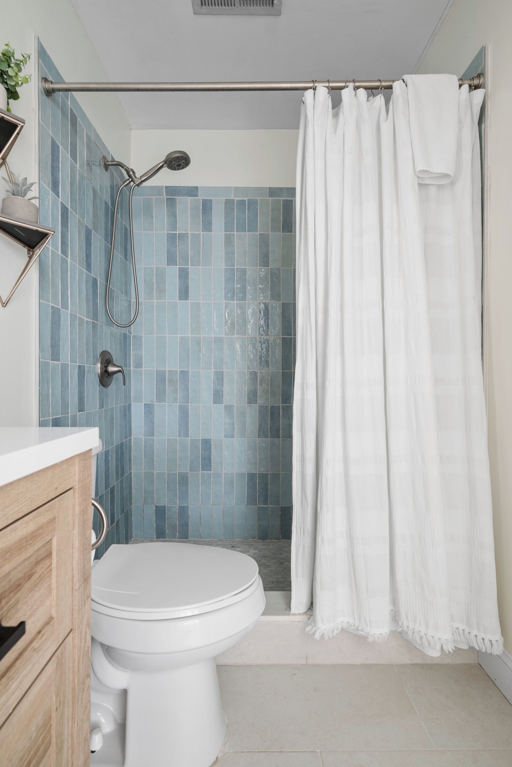 Une salle de bain avec une douche, des toilettes et un porte-serviettes.