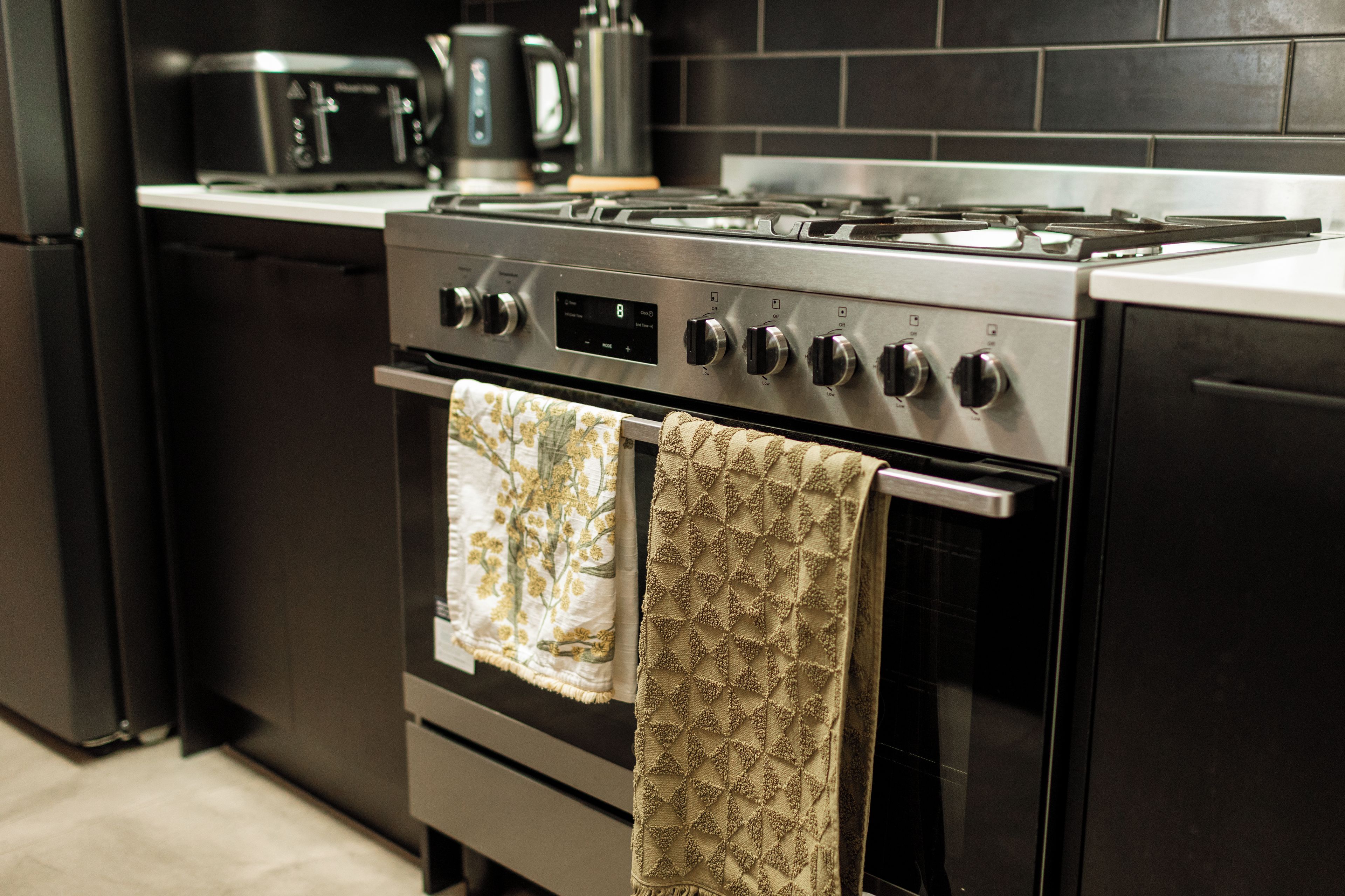 A kitchen with a stainless steel stove, oven, and a microwave on the countertop.