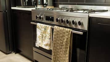 A kitchen with a stainless steel stove, oven, and a microwave on the countertop.