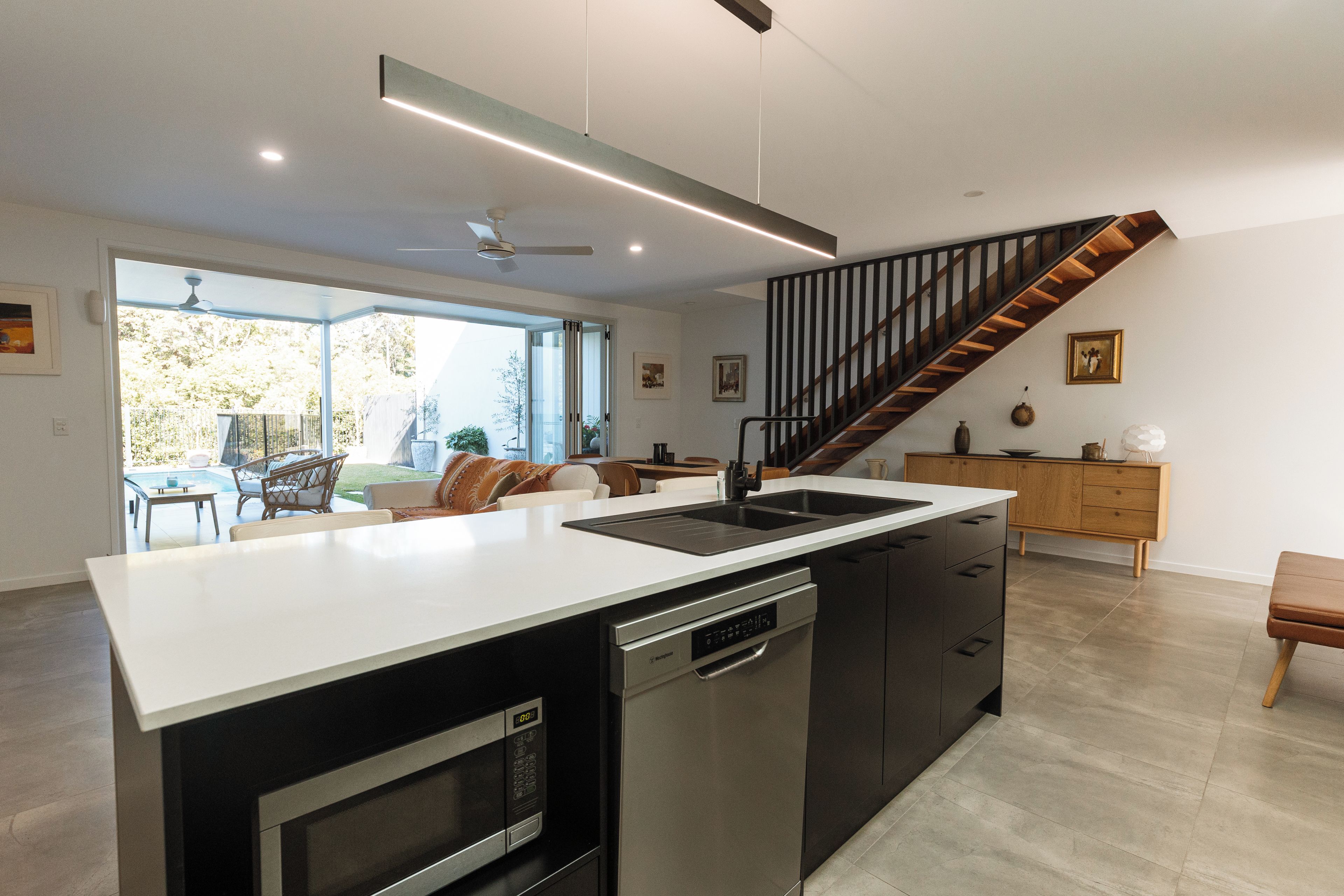 A modern kitchen with a central island, built-in dishwasher, and a stainless steel oven.