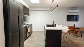 A modern kitchen with a central island, a stove, and a sink.