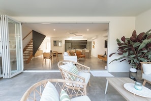 Ein modernes Interieur mit Essbereich, Küche und einer Treppe, die zu einer weiteren Ebene führt.