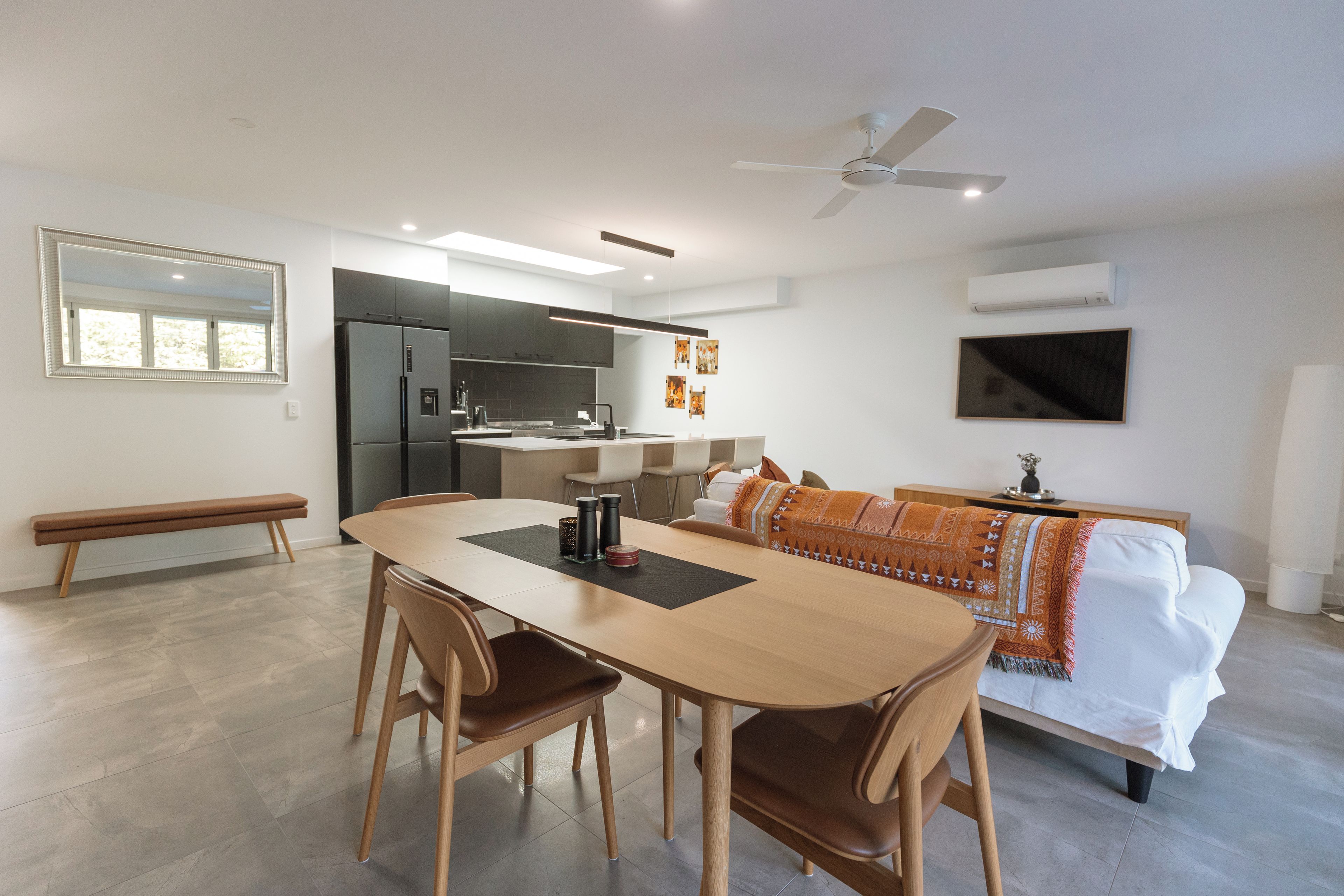 Una cocina moderna con refrigerador, estufa y comedor con mesa y sillas.