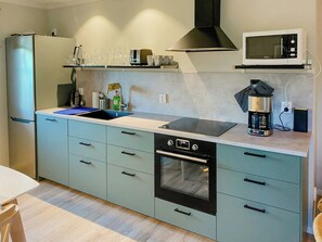 Una cocina moderna con horno empotrado, microondas y fregadero.