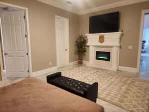 A room with a fireplace, a television mounted above it, and a bench in the foreground. - Four bedroom  in United States of America, Lutz (Lutz)