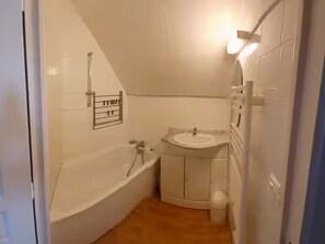Ein kleines Badezimmer mit einer Badewanne, einem Waschbecken und einer Toilette.