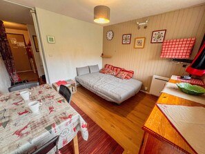 Ein gemütliches Zimmer mit einem Bett, einem Schreibtisch, einem Stuhl und einem Tisch mit Tischdecke.
