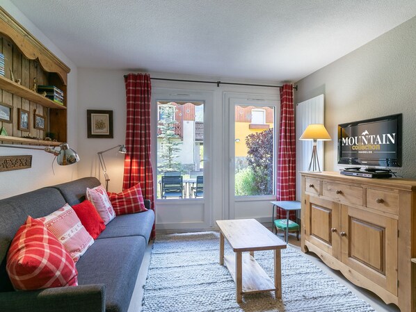 A cozy living room with a sofa, a coffee table, a TV, and a wooden cabinet. - Semi-detached chalet south, shuttle to slope - 7 guests (La Salle-les-Alpes)