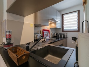 Una cocina moderna con un lavamanos de acero inoxidable, un tostador y una cafetera.