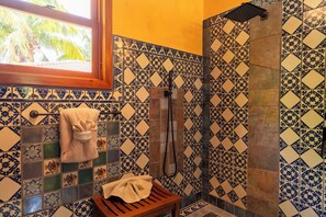 Ein Badezimmer mit Dusche, einer Sitzbank und einem Handtuchhalter.