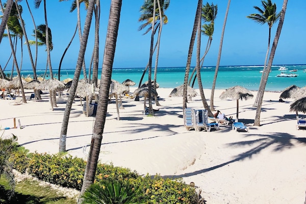 Pantai pribadi di sekitar, pasir putih, dan kursi berjemur