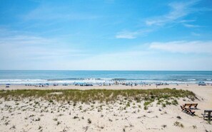 Une plage avec un rivage sablonneux et un ciel bleu dégagé.