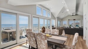 A spacious living area with a large dining table, comfortable seating, and a view of the ocean. - Welcome to an extraordinary OCEANFRONT oasis in the heart of N Beach Haven LBI!! (Long Beach)