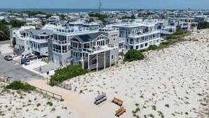 A beachfront property with multiple-story buildings, a sandy beach, and a clear view of the ocean. - Welcome to an extraordinary OCEANFRONT oasis in the heart of N Beach Haven LBI!! (Long Beach)