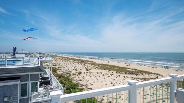 A beach view from a balcony with a pool, beach chairs, and umbrellas. - Welcome to an extraordinary OCEANFRONT oasis in the heart of N Beach Haven LBI!! (Long Beach)