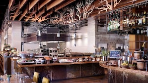A bar area with a central counter, various food items, and a selection of bottles. - Experience Luxury and Family Fun at The Ritz-Carlton Club, Lake Tahoe- 3 Bd. Res (Truckee)