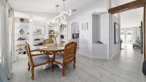 A dining area with a round table and chairs, a white wall with shelves, and a wooden floor. - Elegant & Cozy 3-Bedroom Home in Ocala – Perfect for a Relaxing Stay (Ocala)
