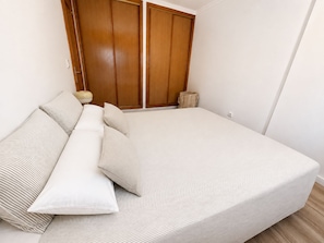 A bedroom with a bed, pillows, a bedside table, and a wardrobe. - Montemar | An 8-minute walk from the beach (Torremolinos)