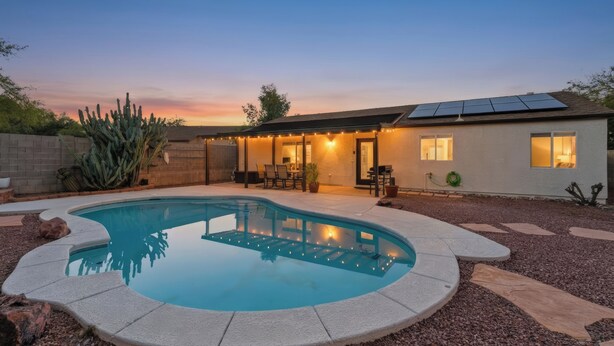 A residential property with a swimming pool, patio, and solar panels. - Remodeled 3BR Home With Private Pool Near Northwest Medical Center And I-10 (Tucson)