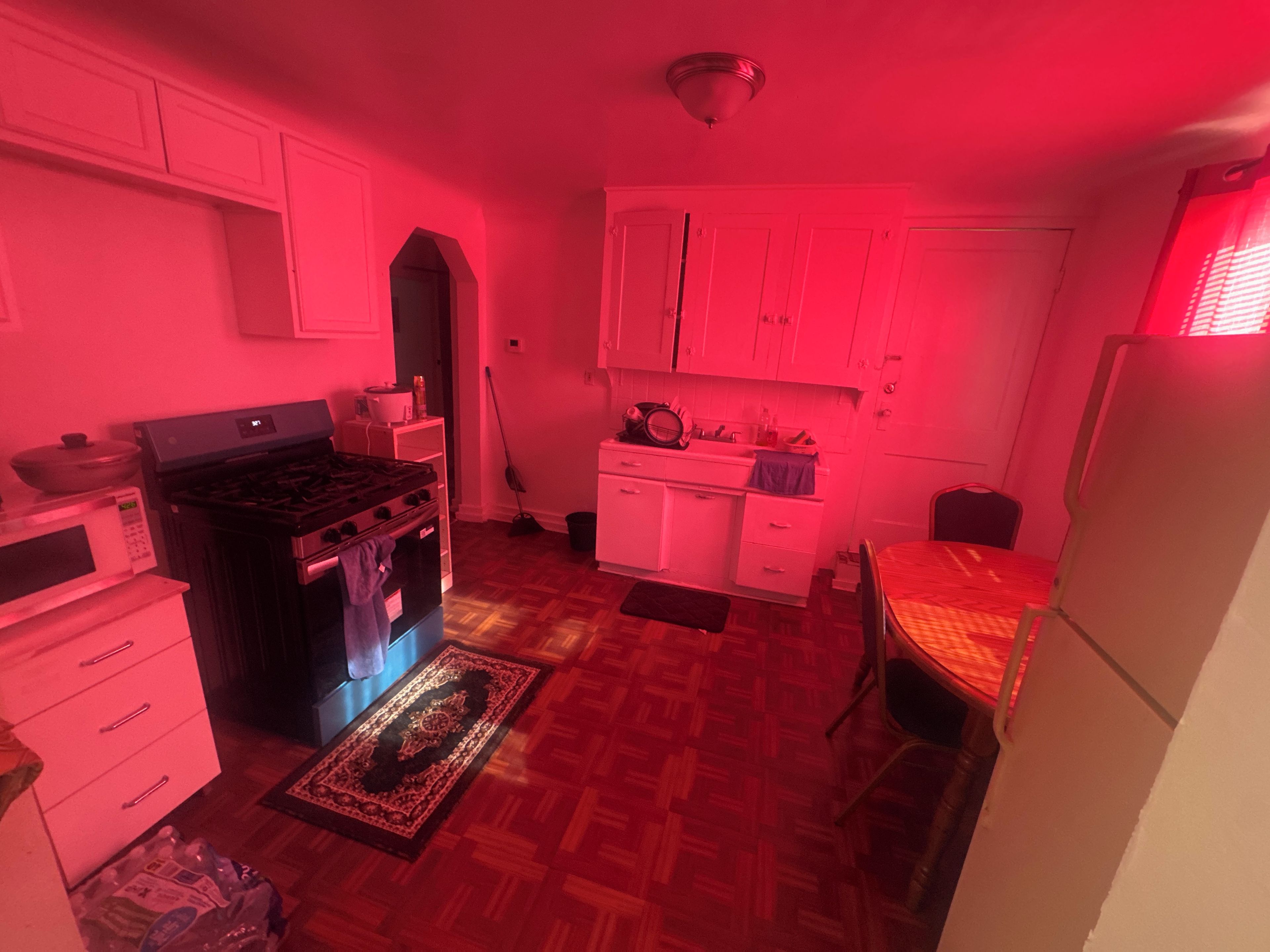 Une cuisine de taille réduite, équipée d’une cuisinière, d’un four à micro-ondes et de placards.