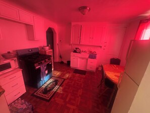 Cozinha compacta com fogão, micro-ondas e armários.