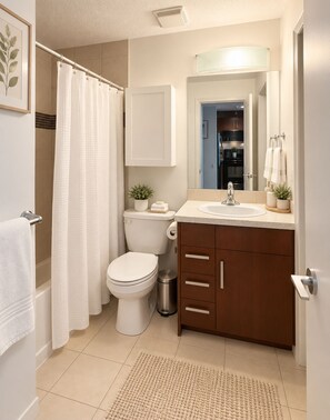 Un baño moderno con inodoro, lavabo y zona de ducha.
