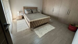 Een slaapkamer met een bed, een kast en een nachtkastje.