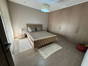 Une chambre à coucher avec un lit, une armoire et une table de chevet.