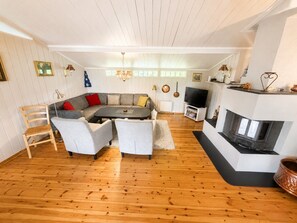 A living room with a sofa, chairs, a fireplace, and a television. - Trysilfjell Ski in Ski out Family Cabin (Trysil)