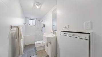 A modern bathroom with a toilet, sink, and shower.