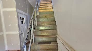 A staircase with wooden steps and metal railings, leading to an upper floor.