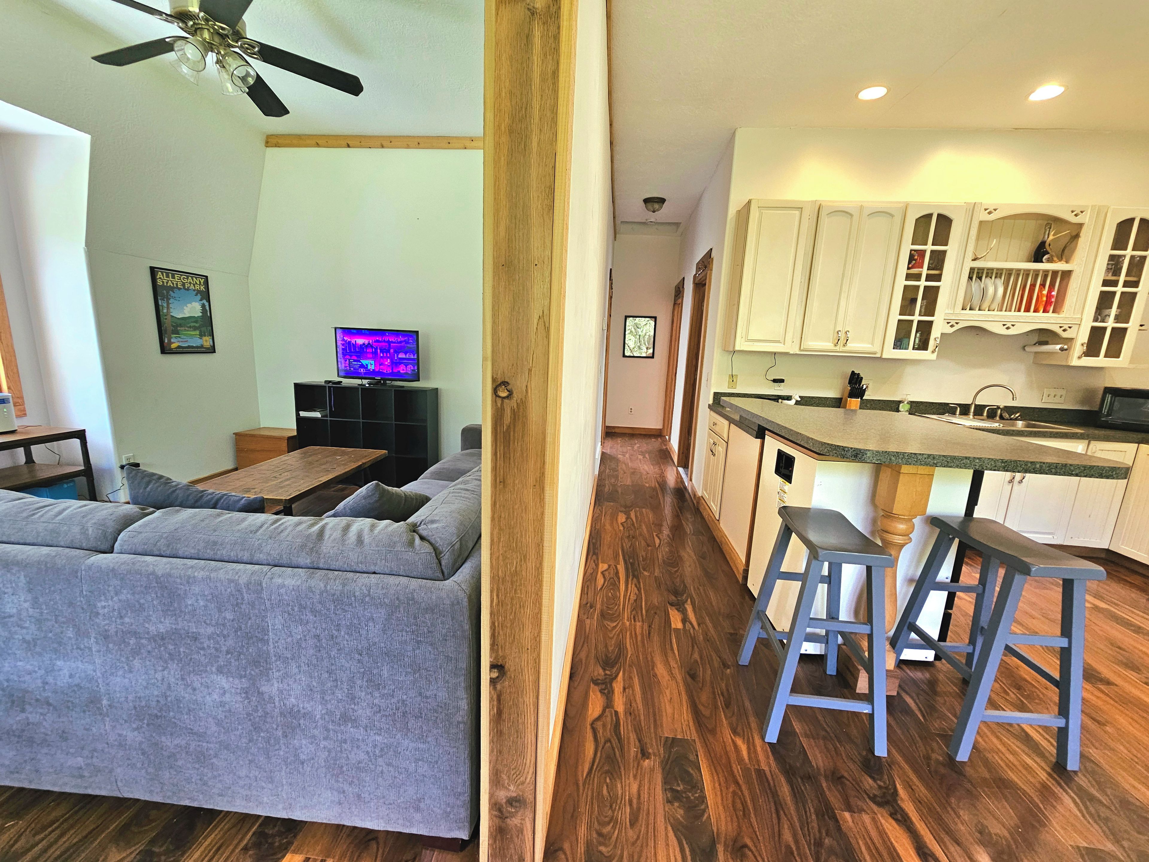 A living room with a sofa, a television, and a wooden floor.