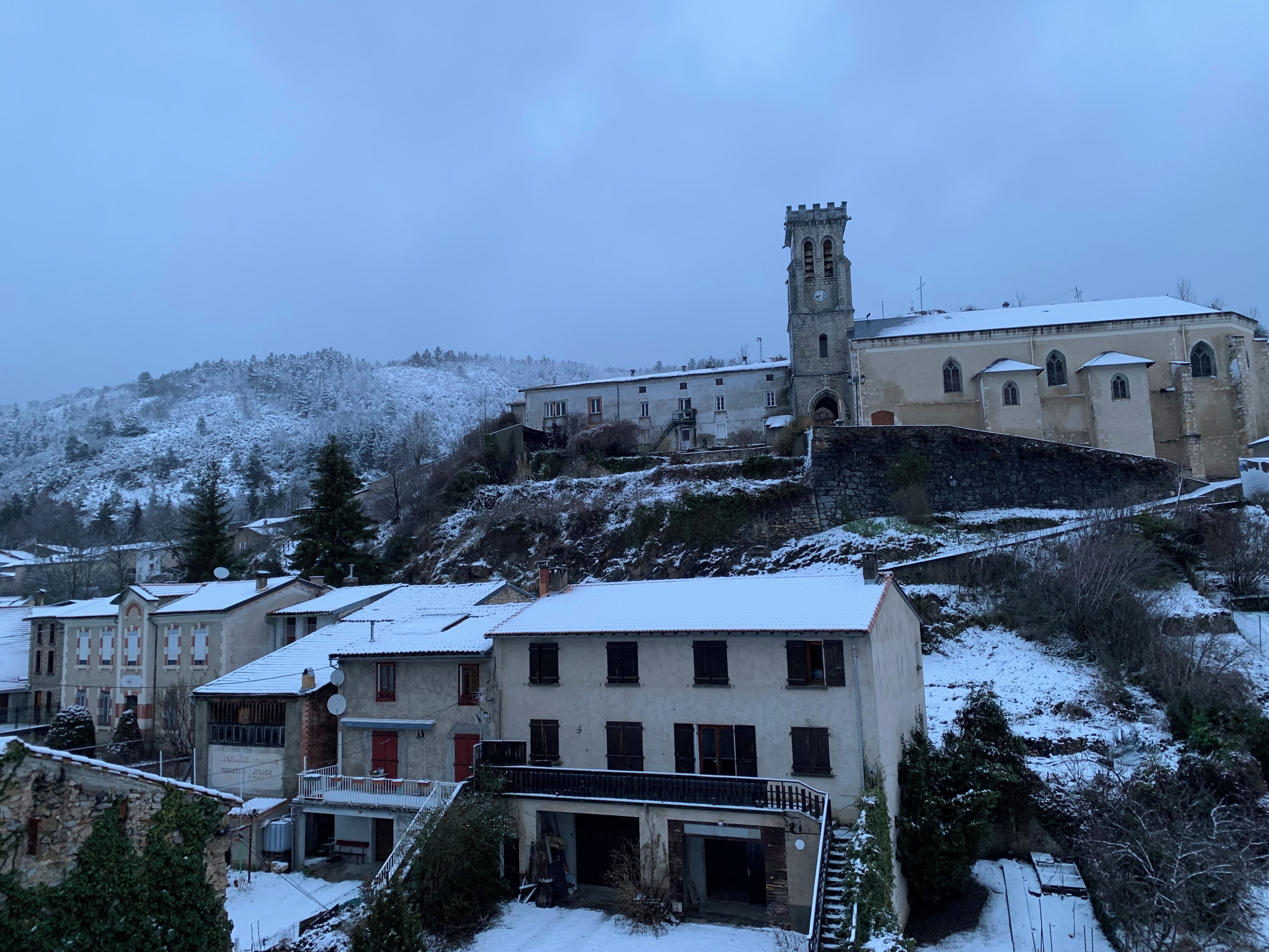 A snow-covered town with historic buildings and a prominent tower.