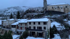 Un pueblo cubierto de nieve con edificios históricos y una torre destacada.