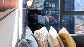 A window seat with a view of a cityscape, a lamp, and a cushion. - Cloud 45 City Views in Southbank (Southbank)
