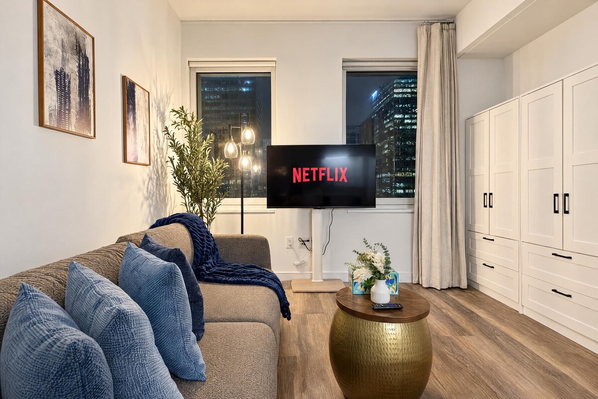 A modern living room with a sofa, a coffee table, and a TV displaying 'NETFLIX'.