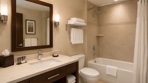 A modern bathroom with a double sink, a toilet, and a bathtub. - Midtown Highrise Condo Near Times Square (New York)