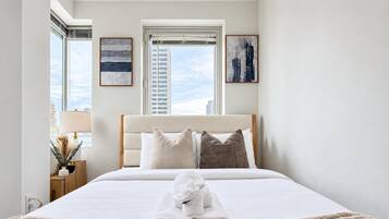 Una camera d'albergo con un letto, una finestra e opere d'arte alle pareti.