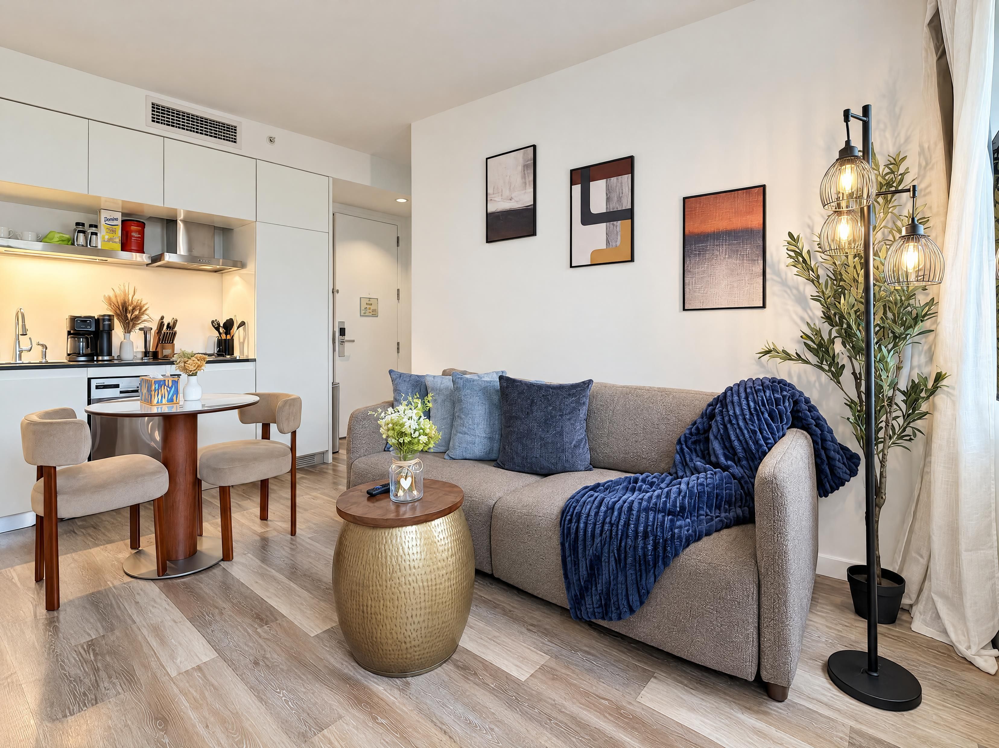 Uma sala de estar moderna com um sofá, mesa de centro e área de jantar com cadeiras.