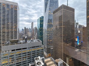 Un paisaje urbano con modernos edificios de gran altura, incluyendo un edificio con un patrón vertical característico y otro con fachada de vidrio reflectante.