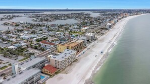 An aerial view of a coastal city with a long beach, dense residential area, and a marina. - Cozy Oceanfront 2-bedroom condo in Madeira Beach - Sleeps 6 (Madeira Beach)