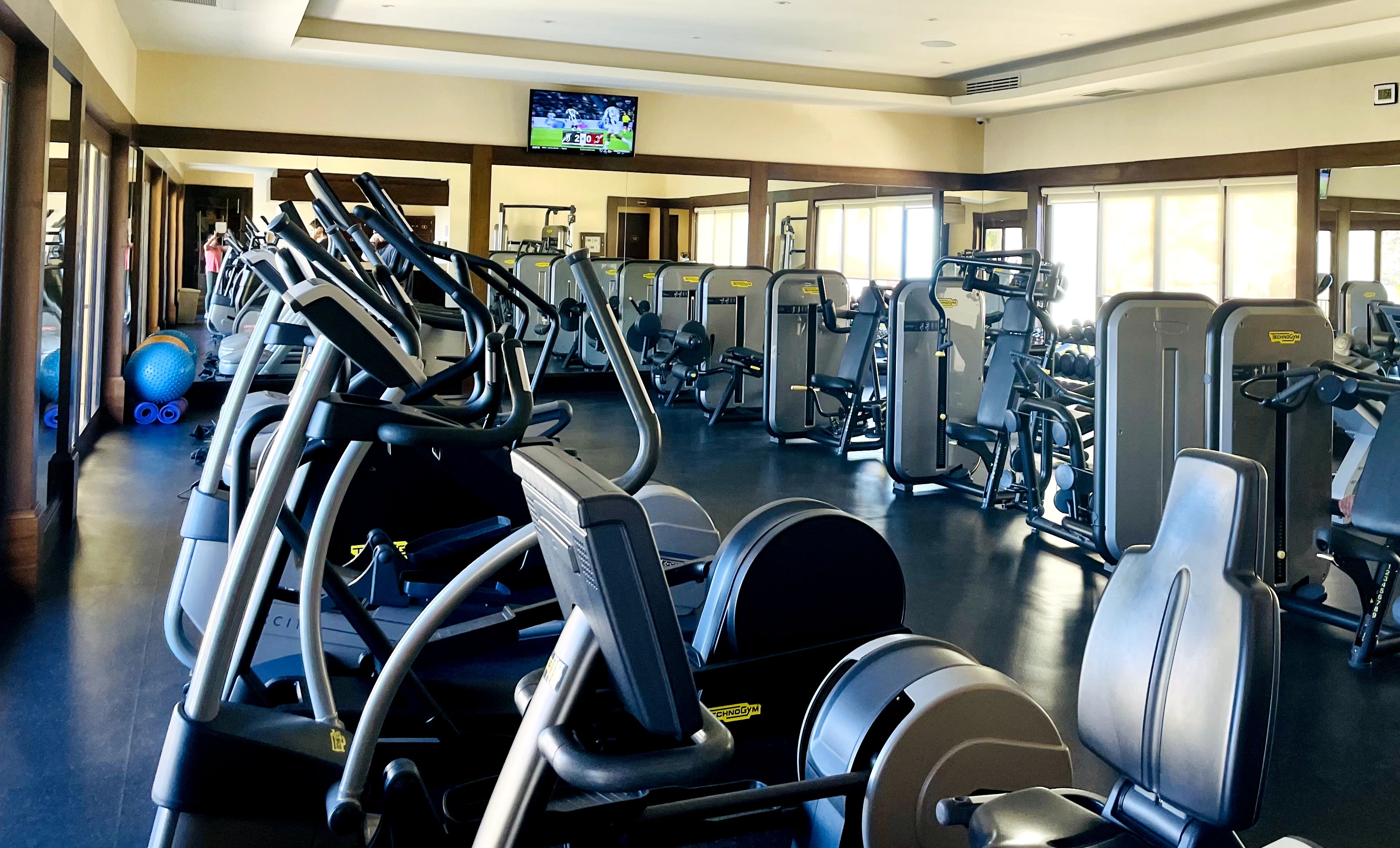 A gym with treadmills, weight machines, and exercise balls.