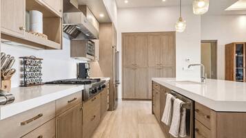 A modern kitchen with stainless steel appliances, wooden cabinets, and a built-in oven.