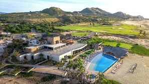 A resort with a swimming pool, a golf course, and a mountainous backdrop. - Sophisticated 4BR Oceanview Retreat w/ Hot Tub (Cabo San Lucas)