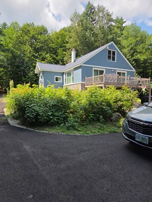 A two-story house with a balcony, surrounded by dense greenery. - Adorable 1-bedroom apartment in Conway perfect for your getaway (Conway)
